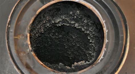 Fotografía del proceso donde se observa el huevo cubierto de hollín negro sobre la llama de una vela.