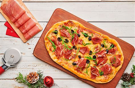 Ilustración de los ingredientes para la pizza de jamón serrano, mostrando la masa, el tomate, quesos y lonchas de jamón.