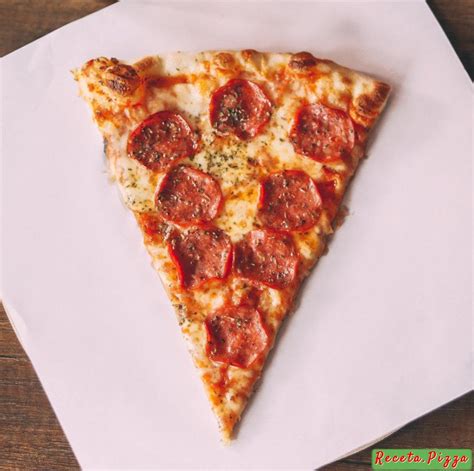 Persona doblando una porción de pizza al estilo neoyorquino