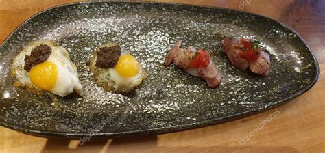 Fotografía de primer plano de un nigiri de huevo con trufa, creación icónica del chef.