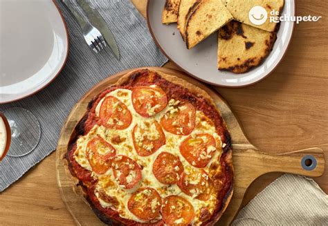 Fotografía gastronómica de una pizza rectangular acompañada de una porción de fainá tradicional.