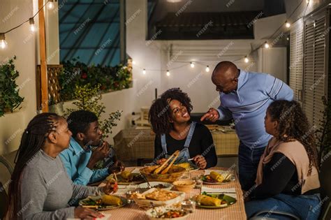 Una familia reunida alrededor de una mesa compartiendo un plato de ñoquis