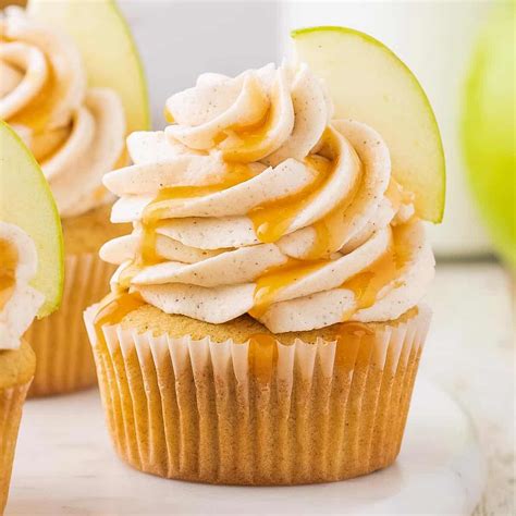 Ilustración de cupcakes de manzana y canela decorados con motivos otoñales y fantasmas.