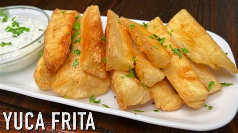 Yuca frita dorada y crujiente servida con salsa