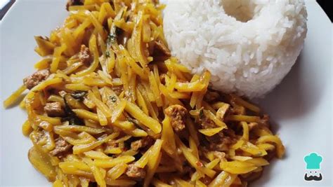 Fotografía gastronómica de un plato de olluquito servido con arroz blanco y hierbas frescas