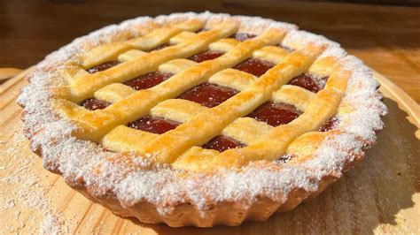 Fotografía profesional de una pasta frola sin gluten recién horneada con el clásico enrejado y relleno de membrillo brillante