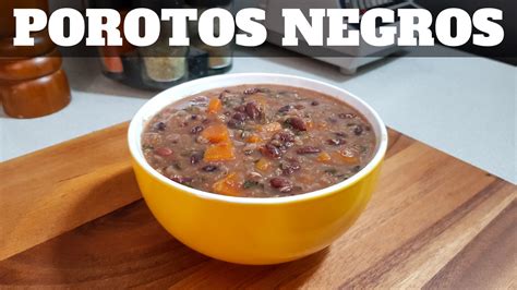 Porotos negros cocidos en una olla y una porción siendo molida con mini pimer