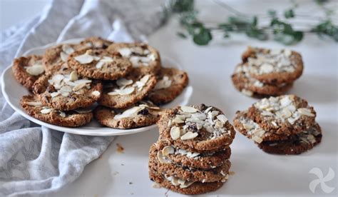 Foto de cerca de galletas de coco y dátiles decoradas con chocolate blanco y coco rallado.