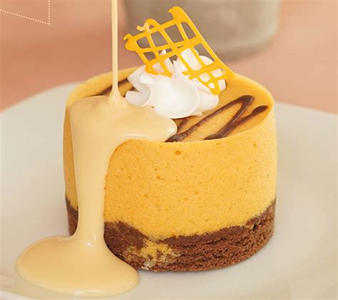 Fotografía de un mousse de lúcuma servido en una copa de cristal con una textura suave y color amarillo intenso.