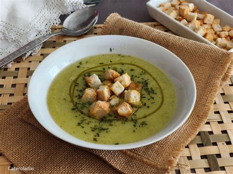 Primer plano de las verduras (puerro, patata, calabacín) sofriéndose en una cazuela.