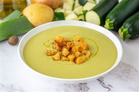 Plato de puré de patata y calabacín presentado de forma atractiva con guarniciones.