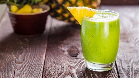 Ingredientes frescos para el jugo de aloe vera, papaya y piña: trozos de piña, papaya, apio, hoja de aloe vera y un vaso de agua.