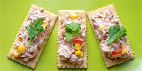 surtido de bocaditos de atún sobre galletas saladas en una bandeja