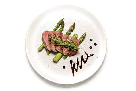 Primer plano de un plato de filete bellamente emplatado con guarnición fresca