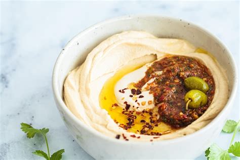 Salsa Amba en un plato, con un fondo de comida israelí como falafel o shawarma