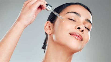 Imagen de una persona aplicándose aceite en el rostro de forma delicada