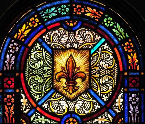 vidriera de iglesia con flor de lis y simbología cristiana