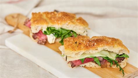 Fotografía cenital de un sándwich de focaccia abierto mostrando las capas de pollo, tomate y lechuga fresca.