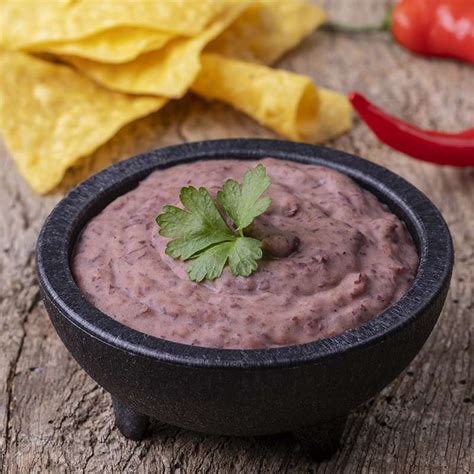 Porción de frijoles refritos cremosos, servidos en un tazón pequeño.