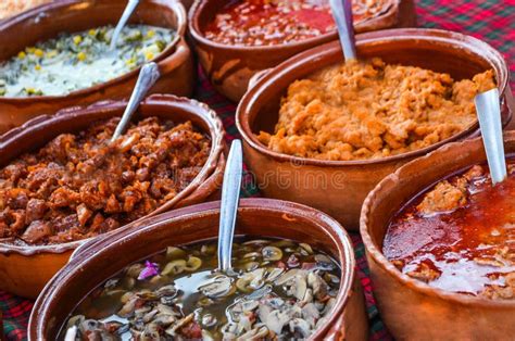 Variedad de guisos mexicanos en cazuelas de barro, listos para servir.