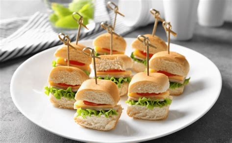 Fotografía de primer plano de mini sándwiches gourmet con corazones de alcachofa y brotes verdes.