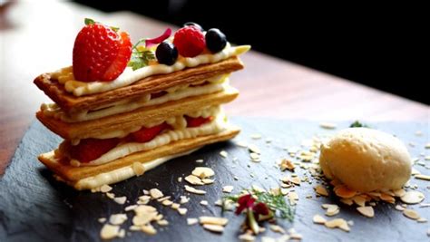 fotografía: torta de milhojas decorada con frutas rojas y una copa de champagne
