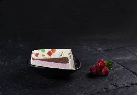 Fotografía gastronómica mostrando el corte transversal de una cassata helada con sus capas diferenciadas.