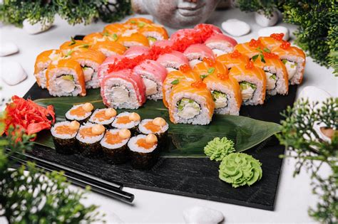 Plato variado con diferentes tipos de rolls de sushi y salsas