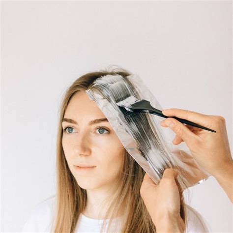 Mujer aplicando tinte de cáscara de nuez en su cabello
