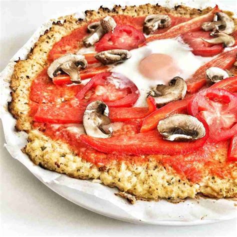 Imagen de una pizza de coliflor terminada con diversos toppings.