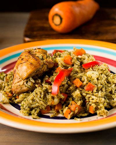 Plato de arroz verde servido con una guarnición de pollo y verduras frescas