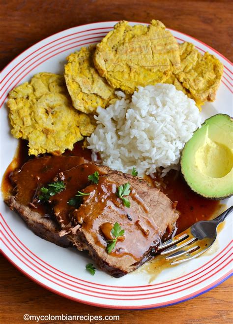 Imagen de posta negra colombiana servida con champiñones y acompañamientos