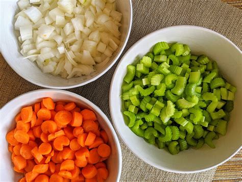Fotografía de ingredientes frescos para mirepoix: cebolla, zanahoria y apio.