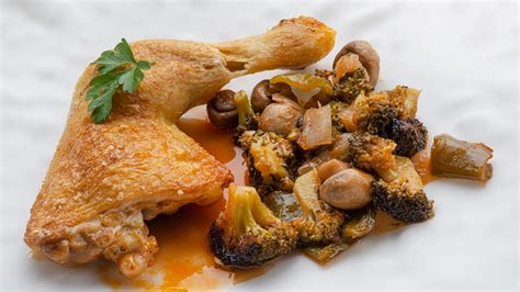 Fotografía de los muslos de pollo confitados con la piel dorada y crujiente.