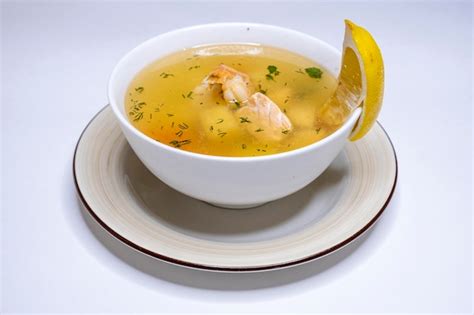 Sopa de mariscos servida en un plato hondo, decorada con perejil fresco y un toque de pimienta