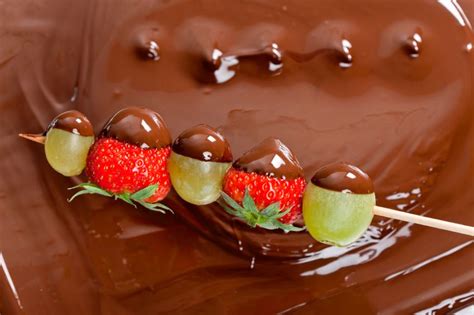 Imagen de diversas frutas bañadas en cobertura de chocolate saludable.