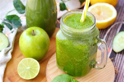 Un vaso de jugo verde vibrante hecho con zanahoria y espinaca