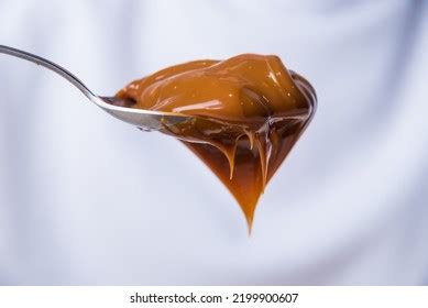 Dulce de leche con cuchara en un frasco de vidrio