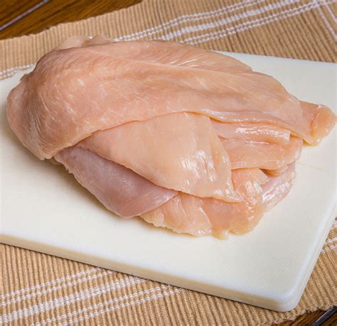 Plato de pechuga de pollo aplanada lista para ser rellenada con jamón y queso.