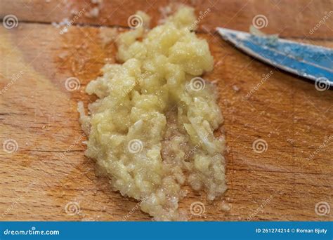 Fotografía de ajo machacado reposando en una tabla de madera para ilustrar la activación de la alicina