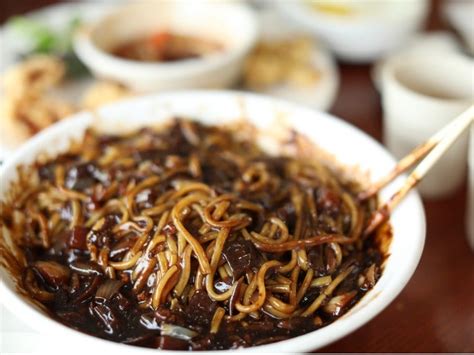 Infografía con los ingredientes principales para preparar Jajangmyeon: fideos negros, pasta de soja negra (chunjang), carne de cerdo, cebolla, calabacín y ajo.