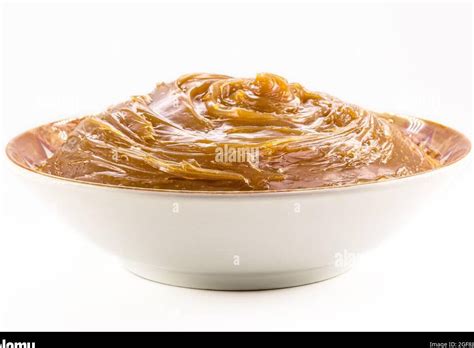 Primer plano de una crema de dulce de leche suave y brillante en un bol.