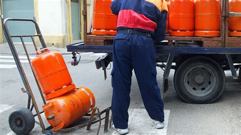 Camión repartidor de bombonas de gas en una calle.