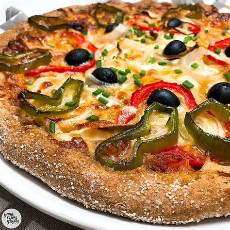 Pizza de espelta integral recién horneada con toppings de verduras y queso