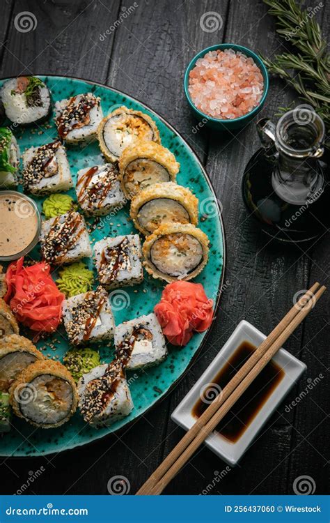 Imagen de un plato de sushi variado con palillos y salsa de soja sobre una mesa moderna.