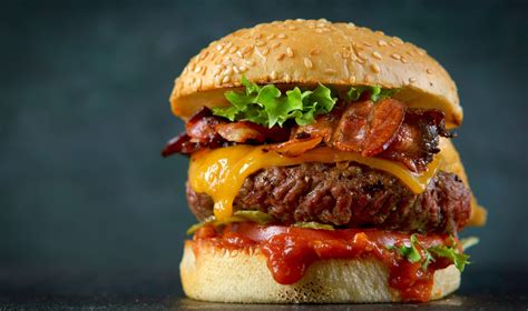 Primer plano de una hamburguesa ahumada jugosa con pan artesanal.