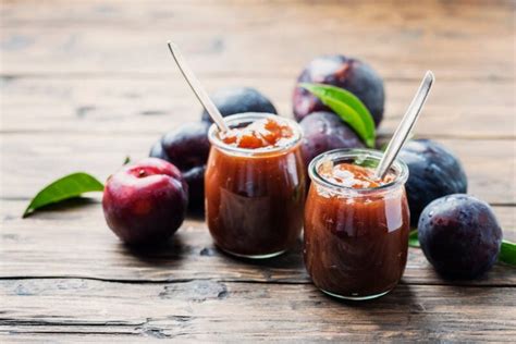 Frascos de mermelada de ciruela casera, recién envasados y boca abajo para el sellado al vacío.