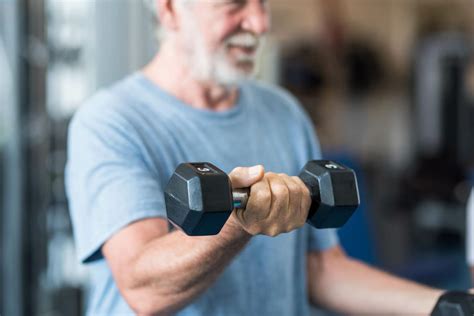 Persona mayor levantando pesas ligeras, mostrando el fortalecimiento muscular