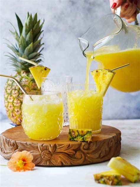 foto de una jarra de agua fresca de piña servida con hielo y rodajas de piña