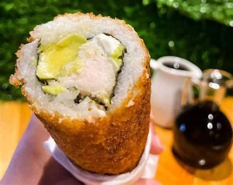 Persona comiendo un hand roll de pollo en la calle